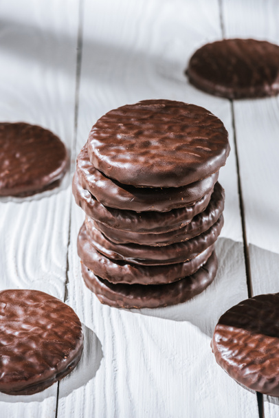 close-up shot of stack of delicious glazed chocolate cookies on white wooden table - Foto, Bild