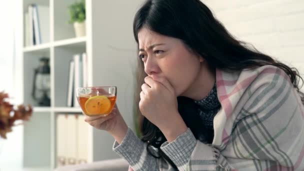 Asiatique femme obtient froid et tousse elle boire du thé au citron chaud pour la laisser se sentir mieux dans le salon à la maison
. - Séquence, vidéo