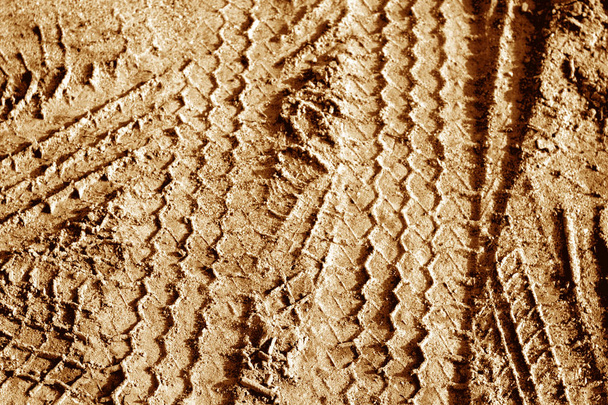Tyre tracks on sand in orange tone. - Photo, Image