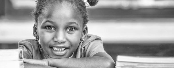Ευτυχισμένος Αφρικανική κορίτσι στο σχολείο, στο γραφείο της. - Φωτογραφία, εικόνα