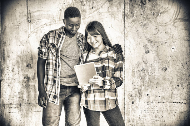 Coppie di adolescenti misti che usano tablet isolato su sfondo bianco. Concetto di integrazione
. - Foto, immagini