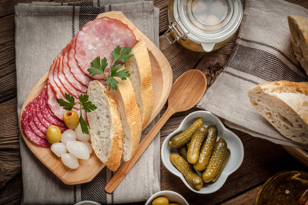 Tapas with sliced sausage, salami, olives, marinated onions, cuc - Foto, Imagem