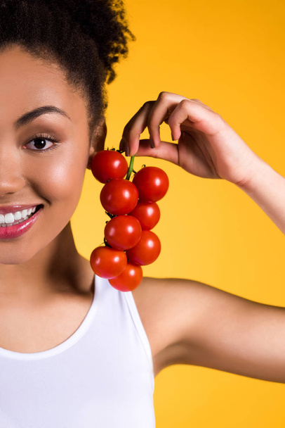Black girl holding tomatoes branch isolated. - 写真・画像