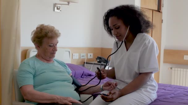 infirmière mesurant la pression artérielle chez la femme âgée à l'hôpital. Concept de santé et retraite
 - Séquence, vidéo