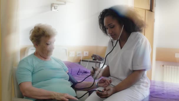 ölçüm tansiyon için yaşlı kadın hastanede hemşire. Sağlık ve emeklilik kavramı - Video, Çekim