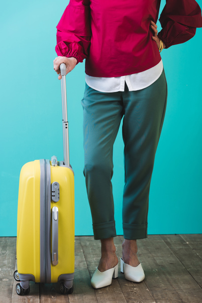 low section view of female traveler with yellow suitcase - Фото, изображение