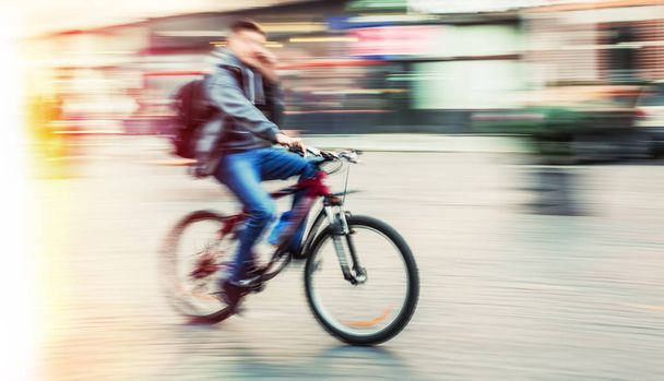 Pyöräilijä liikkeessä hämärä
 - Valokuva, kuva