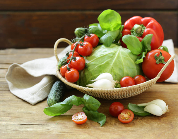 fresh spring vegetables in a basket on a wooden table - Foto, Bild