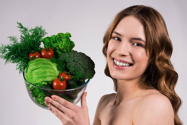 Happy girl posing with bowl of vegetables isolated - Foto, Bild