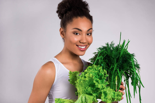 Yeşillik ve izole salata tutarak siyah kız. - Fotoğraf, Görsel