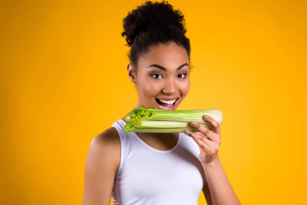 African American girl holding celery isolated. - Foto, immagini