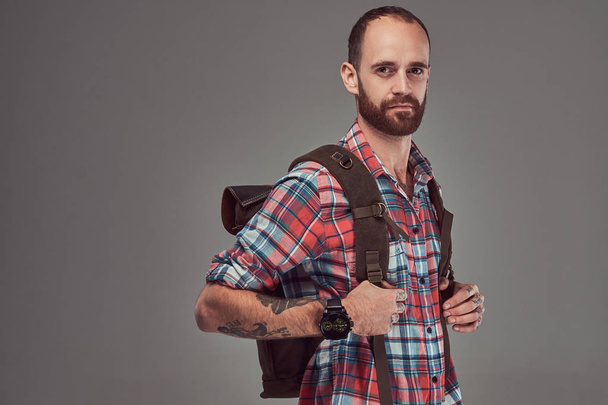A szép tetovált traveler a flanel ing egy hátizsák, állandó stúdióban portré. - Fotó, kép