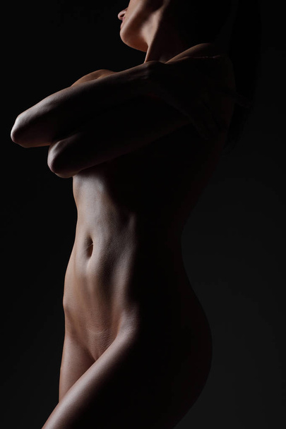 nagie piękne kobiece ciało na ciemnym tle - Zdjęcie, obraz