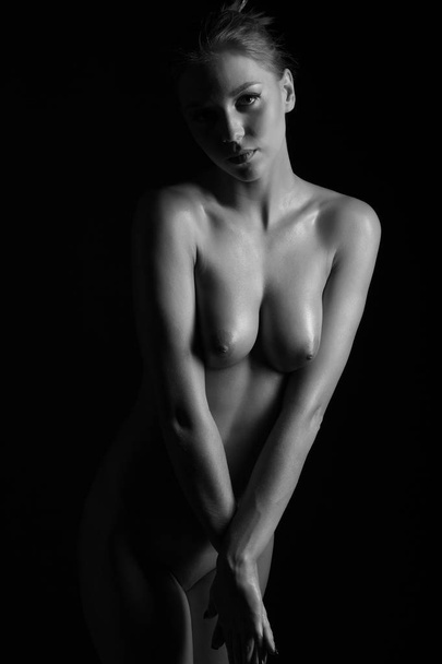 nude beautiful female body on a dark background - Foto, Imagem