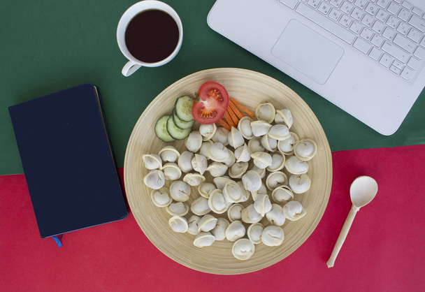 almuerzo en el lugar de trabajo. portátil, bloc de notas, albóndigas, taza de café en la mesa - Foto, imagen