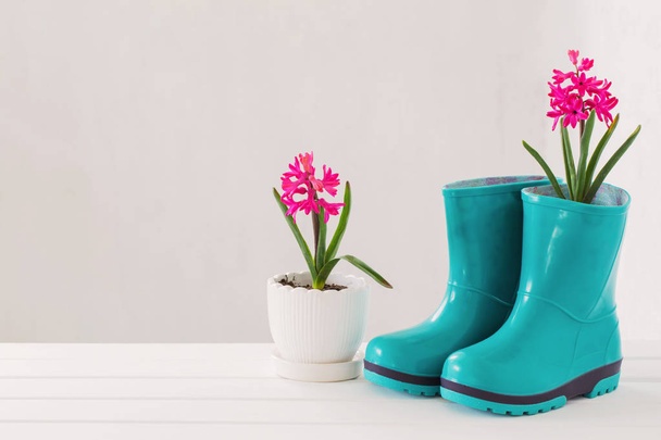 rubber boots and spring flowers on white background - Φωτογραφία, εικόνα