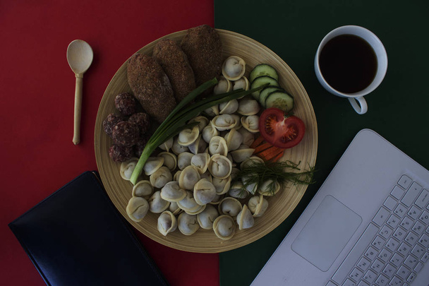 zelfgemaakte dumplings, laptop, koffiebeker op tafel  - Foto, afbeelding