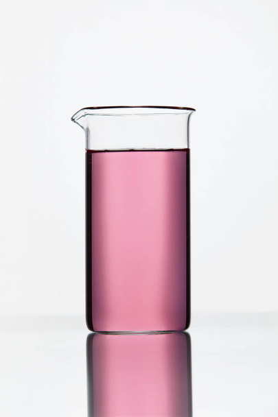 Laboratory Glassware. Glass With Pink Liquid On White Background - Foto, Bild