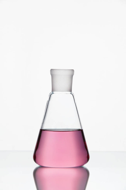 Laboratory Glassware. Glass With Pink Liquid On White Background - Fotoğraf, Görsel