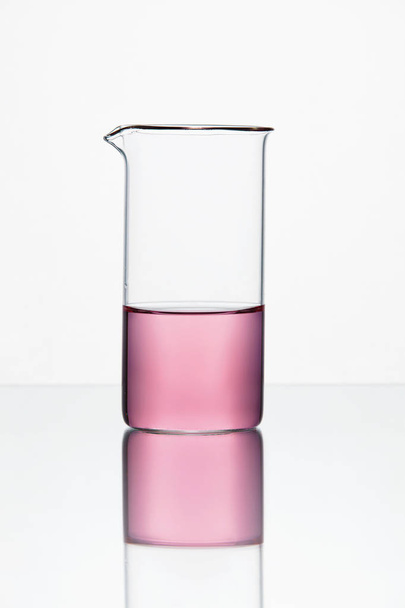 Laboratory Glassware. Glass With Pink Liquid On White Background - Fotó, kép