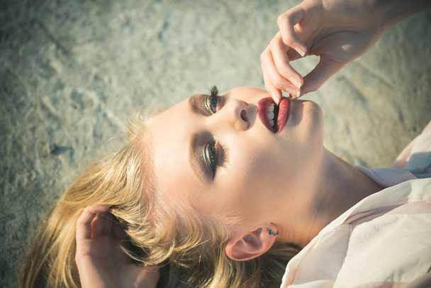 Girl with long blond healthy hair lie on concrete surface - Fotó, kép