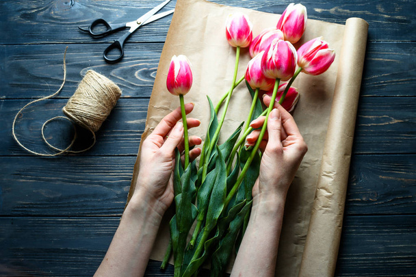 Bouquet de tulipes sur papier d'emballage à la main.Vue du dessus
  - Photo, image