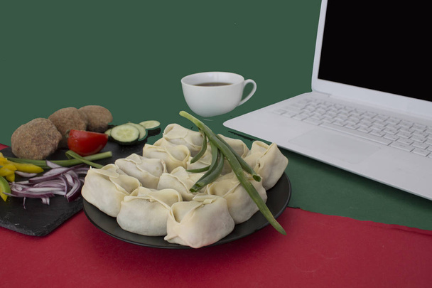 ordenador portátil, albóndigas, chuletas, verduras, taza de café en la mesa - Foto, Imagen