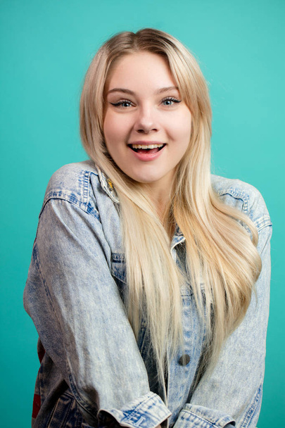 Cheerful Blond Girl isolated on a blue background. - Fotó, kép