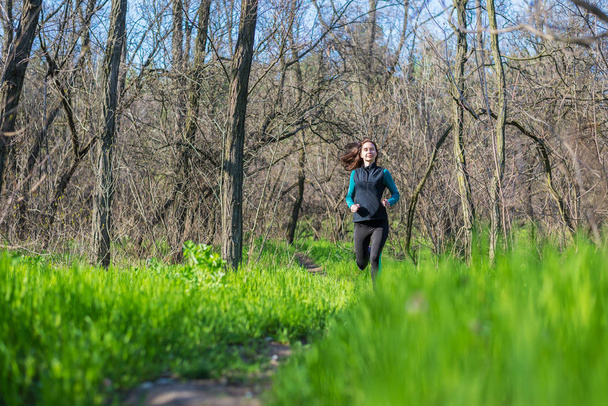 Young woman on a morning run through the spring forest. - Foto, Imagem