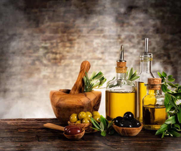 Fresh harvested olives with oil, placed on wooden table - Foto, Imagem