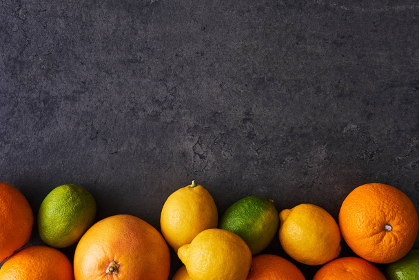 Flat lay of fresh ripe citruses on dark background - Valokuva, kuva