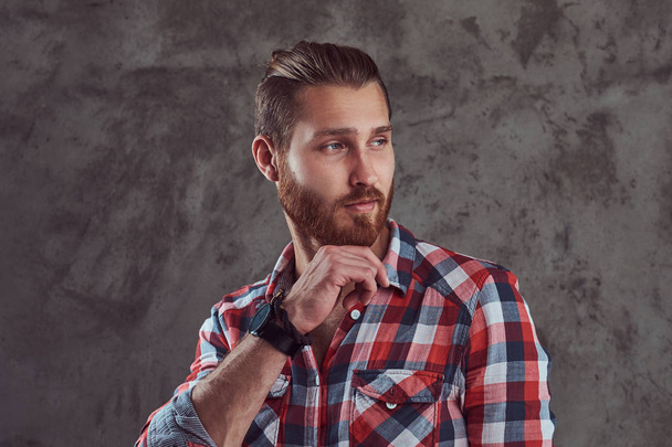 Jeune homme beau modèle rousse dans une chemise en flanelle sur un fond gris
. - Photo, image
