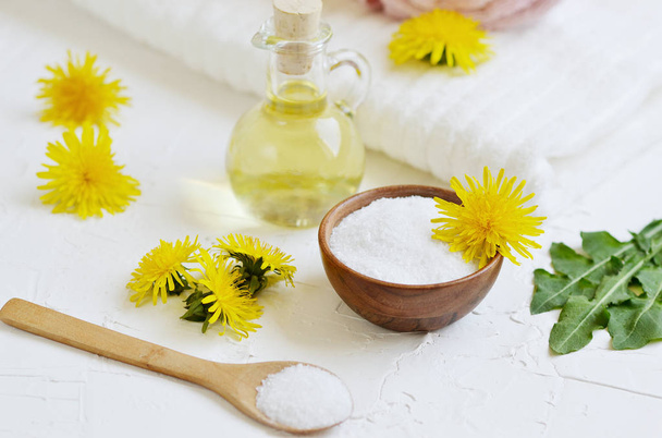 Natural ingredients for homemade body salt scrub with dandelion flowers, lemon, honey and olive oil, SPA concept, white background - Photo, Image