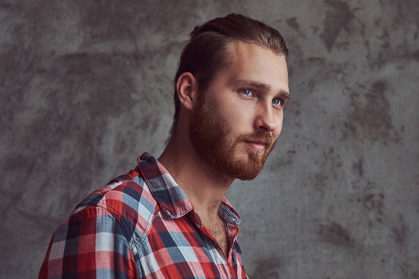 Young handsome redhead model man in a flannel shirt on a gray background. - 写真・画像