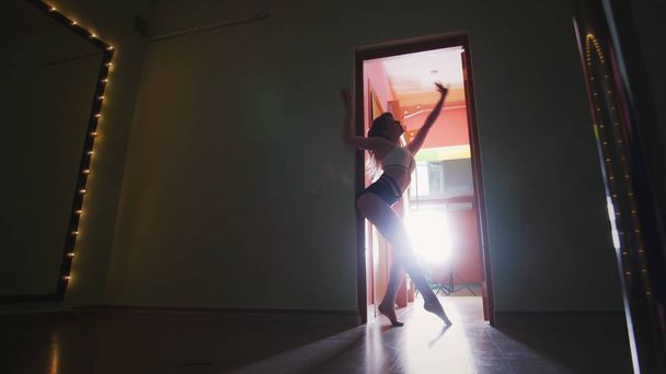 Красива жінка полюс танцівниця в тісному одязі з сексуальною формою танцює на полюсі
 - Фото, зображення