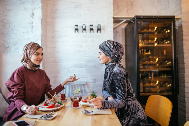 Two Muslim women in cafe, friends meeting - Фото, изображение