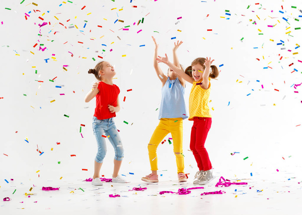 bambini felici in vacanza saltando in coriandoli multicolori su
  - Foto, immagini