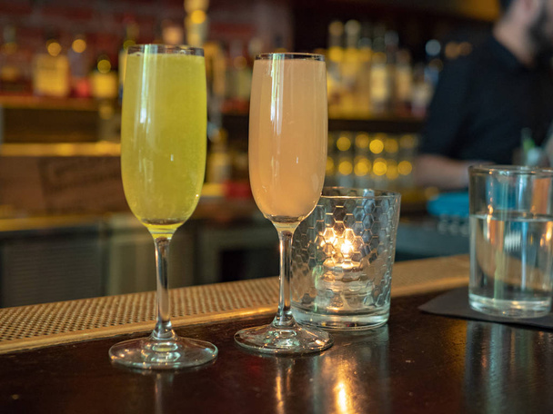 Dois vinhedos cheios de bebidas mimosas sentados em uma contagem de bar
 - Foto, Imagem