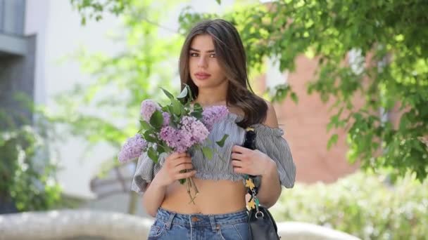 Happy woman keeping lilac flowers - Filmati, video