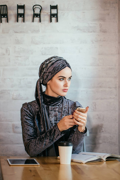 muslim women holding smartphonephone. thinking of good memories. - Valokuva, kuva