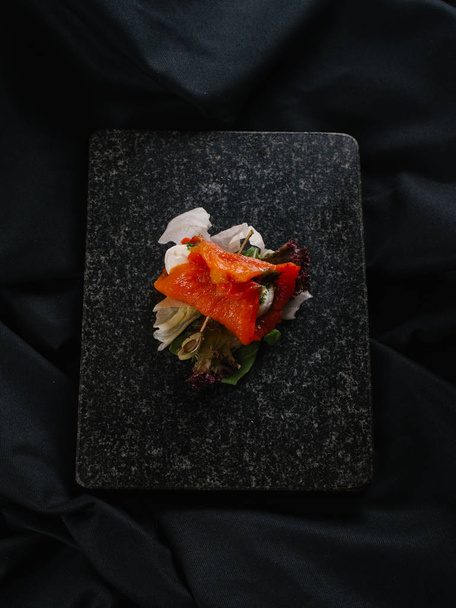 Nahaufnahme von köstlichem Restaurantgericht auf schwarzem Steinschiefer  - Foto, Bild