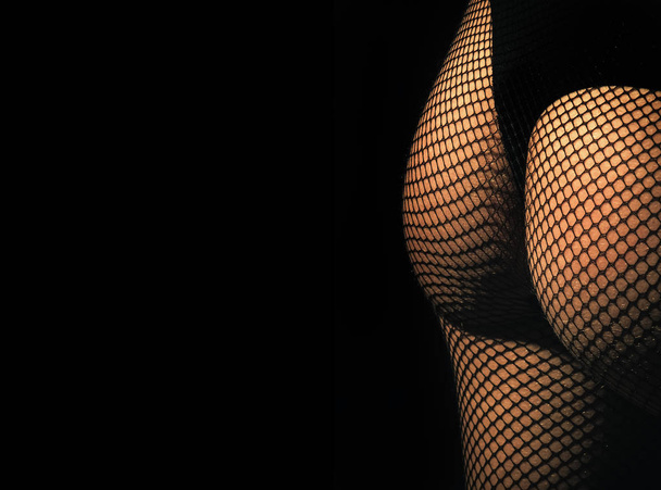 Hips and buttocks wearing black panties and fishnet pantyhose - Photo, image