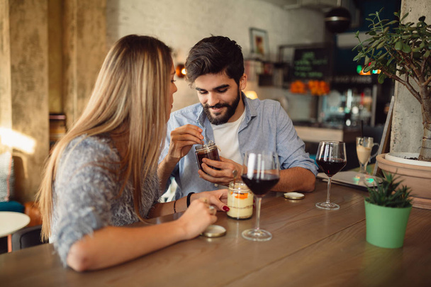 Boldog pár desszert eszik és iszik bor kávézóban ülve  - Fotó, kép