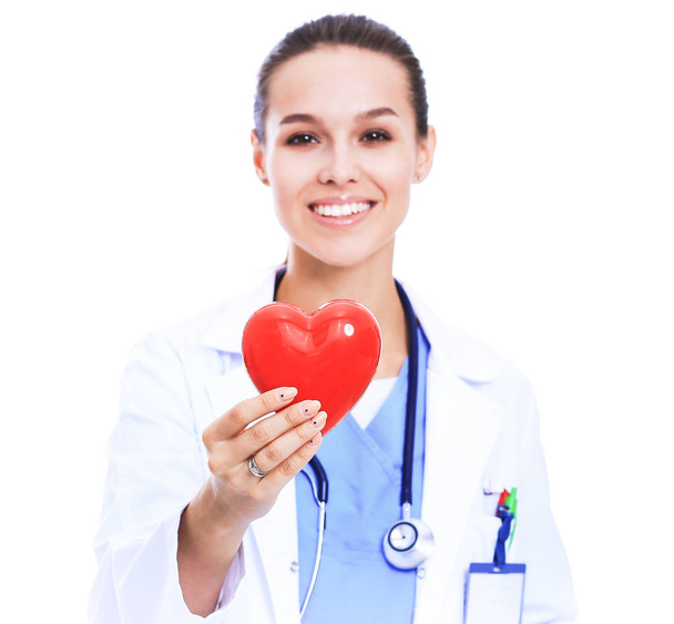 Positive female doctor standing with stethoscope and red heart symbol - Fotografie, Obrázek