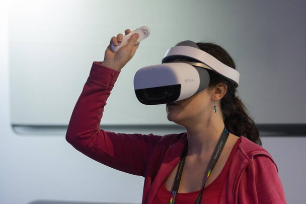 A woman plays a video game using virtual reality glasses - Фото, изображение