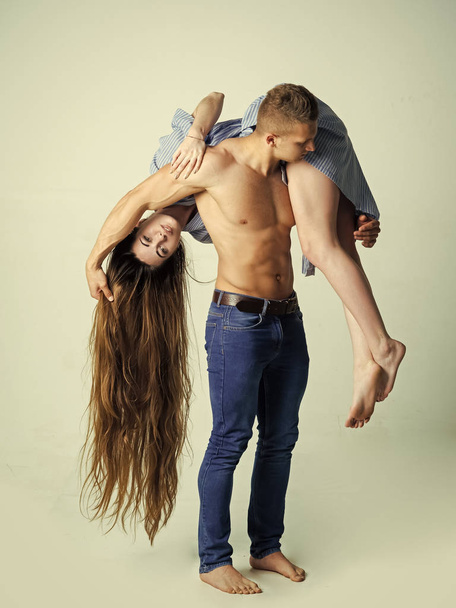Woman with long hair hang on strong man shoulder - Фото, изображение