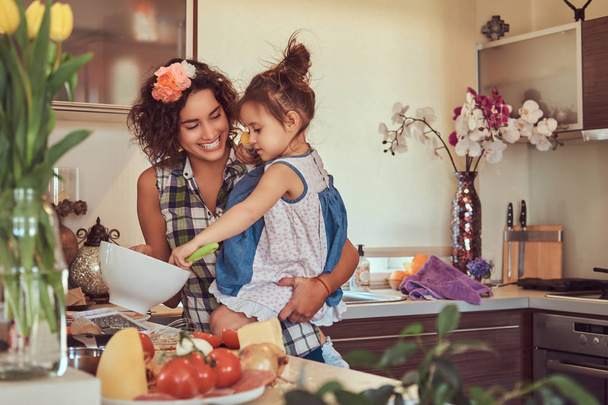 Gyönyörű spanyol anya tanítja a aranyos kis lánya készítsen pizza a konyhában. - Fotó, kép