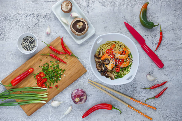 Hot asian wok noodles with shrimps and mushrooms, Preparation ramen, Gray background, Top view - Fotó, kép