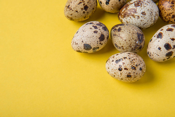 Belos ovos de codorna frescos manchados em um fundo de papel amarelo
 - Foto, Imagem