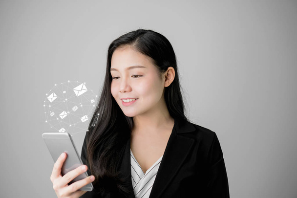 Бизнес-женщина с помощью смартфона и значка с изображением социальной почты, общения и работы в Интернете
. - Фото, изображение